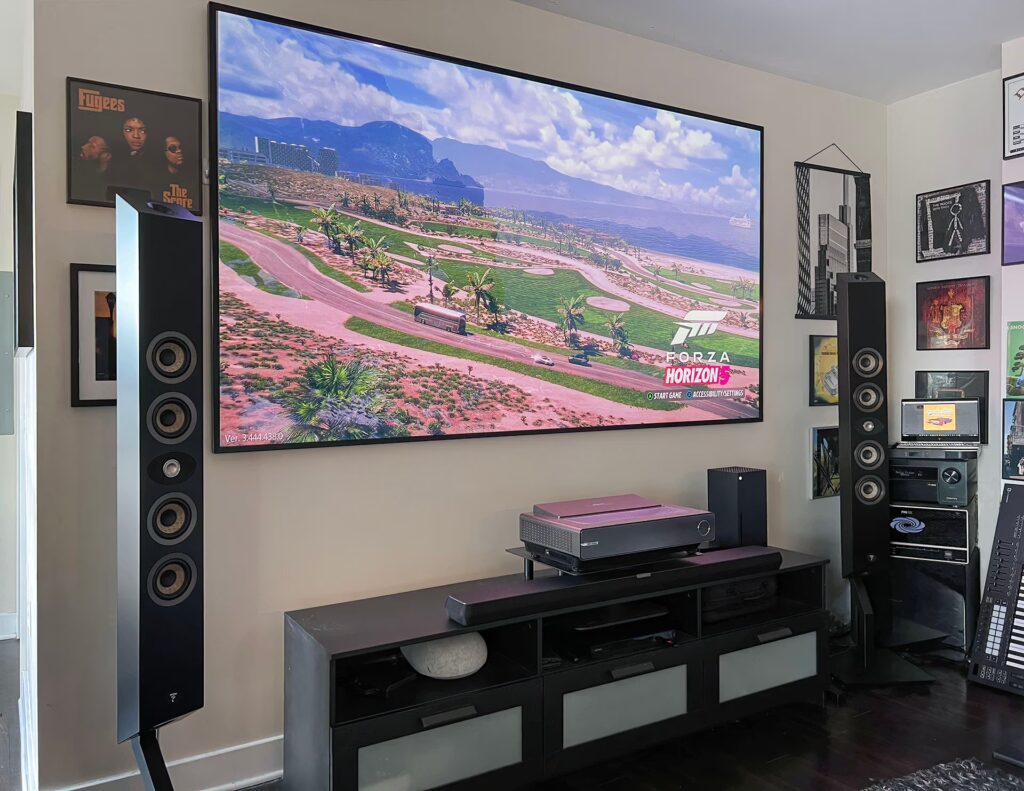 Wall-mounted TV with ambient lighting and surround sound – NeuroWerx home theater and AV installation services.