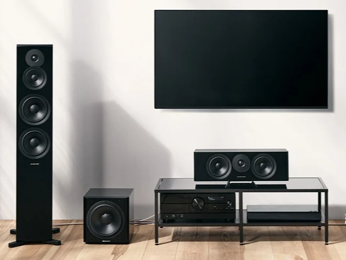 Home surround sound system with TV, floor speakers, subwoofer, and audio receiver.